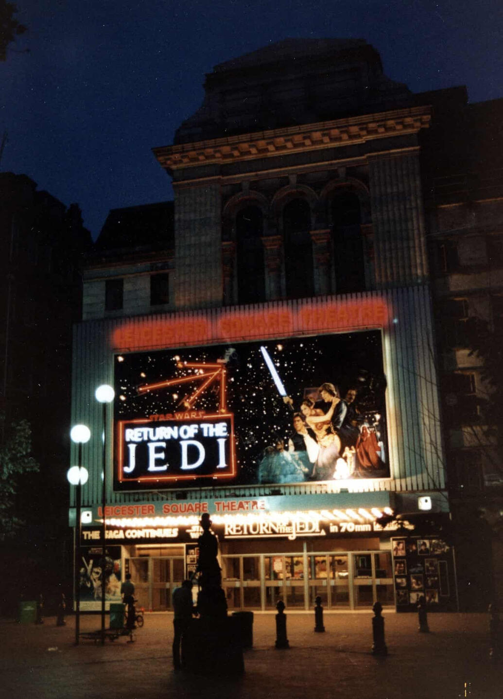 a photo of chappell roan for NME. she is flexing her right arm, which has a red lipstick mark on it.